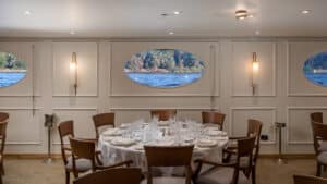 Dining room on the MS Grand Mandarin Nile Cruise with a round table and porthole water views.