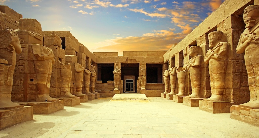 Classic Egypts ancient temple, with statues and hieroglyphics, under a vibrant sky.