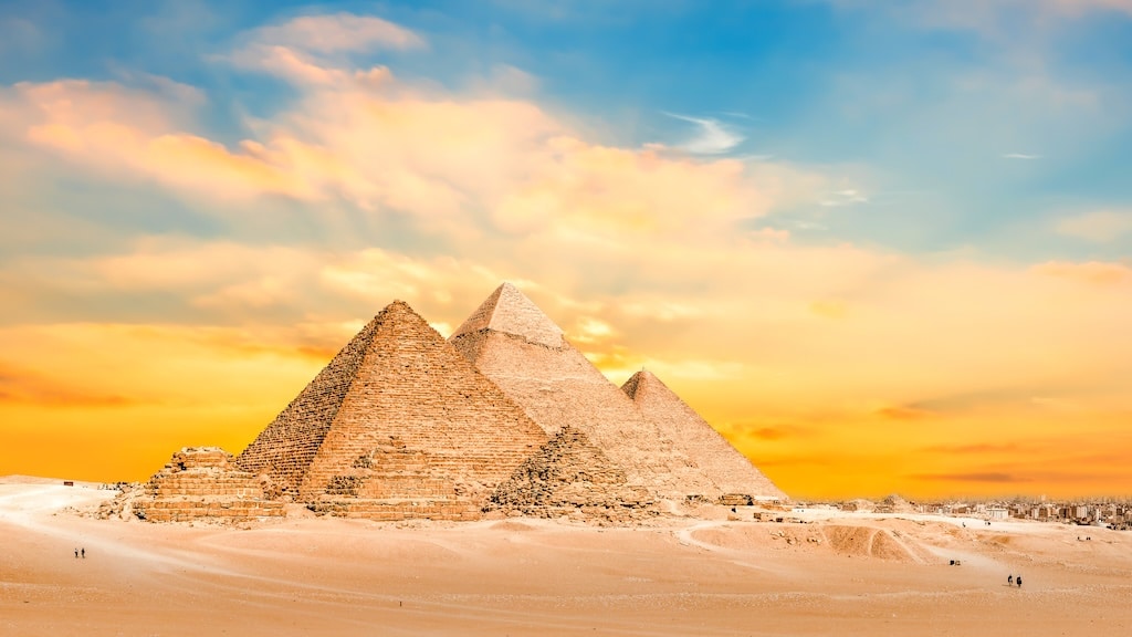 Classic Egypt: Pyramids of Giza silhouetted against a vibrant sunset sky.