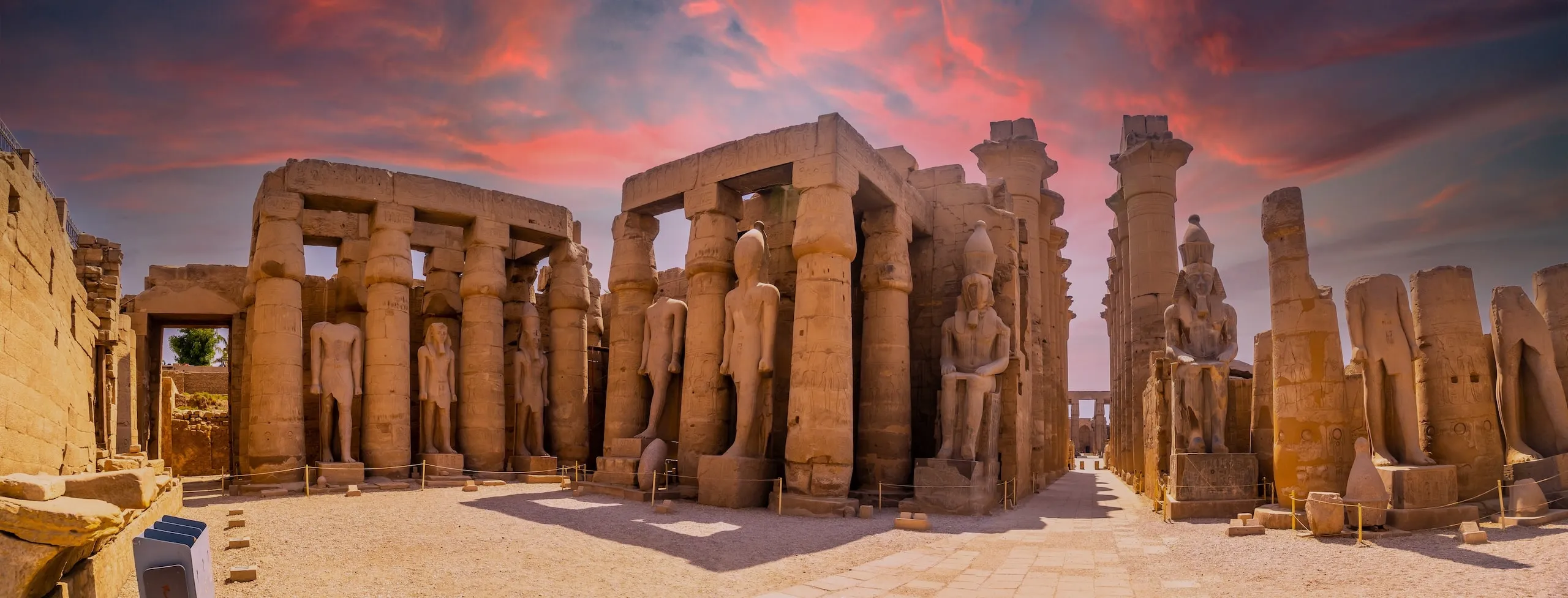 Ancient temple ruins with statues and columns on the Treasures of Egypt Tour at sunset.