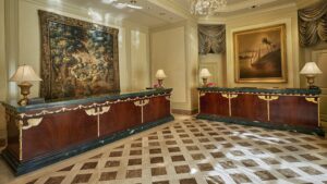 Elegant Four Seasons lobby with check-in counters and decorative wall paintings.