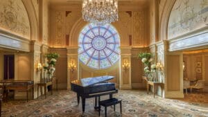Elegant room at Four Seasons with a grand piano and large stained glass window.