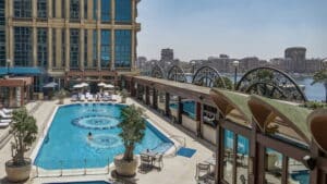 Rooftop pool at Four Seasons with lounge chairs and city skyline view.