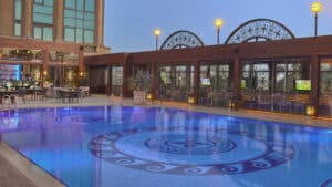 Outdoor pool at Four Seasons, blue lighting, elegant seating, and lamps.