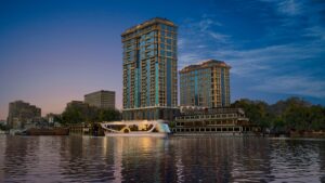 Four Seasons towers by a river at dusk, mirrored in the water.