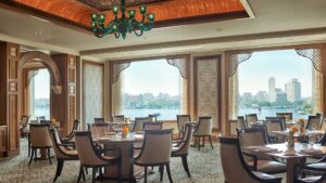 Elegant dining room with large windows overlooking the Nile at the Four Seasons Hotel Cairo.
