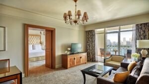 Hotel suite at Four Seasons Cairo with sitting area, TV, and balcony cityscape view.