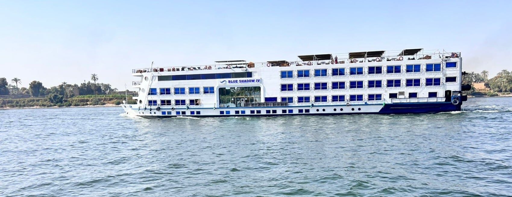 The MS Classic Blue Shadow IV 5* sails gently on the river under a clear blue sky.