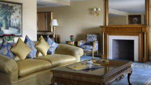 Elegant living room like Cairo Marriotts, with gold sofa, decorative pillows, and fireplace.