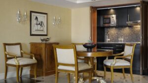 Elegant dining area at Cairo Marriott Hotel with round table, chairs, and open kitchen view.