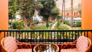 Two chairs and a table on a balcony at Cairo Marriott Hotel, overlooking a lush garden.