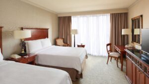 Cairo Marriott room: two beds, desk, chair, and a window with curtains.