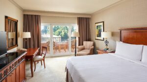 Room at Cairo Marriott Hotel with a bed, desk, TV, and balcony seating.