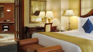Cairo Marriott Hotel room with a bed, desk, lamp, mirror near an open bathroom door.