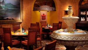Cozy restaurant with wooden chairs, a central fountain, and paintings near Cairo Marriott Hotel.
