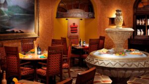 Cozy restaurant at Cairo Marriott Hotel with wooden furniture and a fountain displaying dishes.