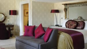 Elegant bedroom at Cairo Marriott with a large bed, purple accents, and a cozy sitting area.