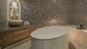 Ornate mosaic-tiled interior at Cairo Marriott Hotel with marble slab and decorative fountain.