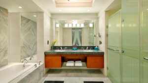 The Nile Ritz-Carlton bathroom: double sinks, large mirror, shower, and bathtub.