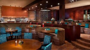 The Nile Ritz-Carltons interior features round tables, brown booths, and turquoise chairs.