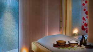 The Nile Ritz-Carlton spa: a serene room with a massage table, candles, bowls, and towels.