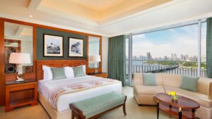 The Nile Ritz-Carlton room: bed, sofa, and large windows with cityscape views.