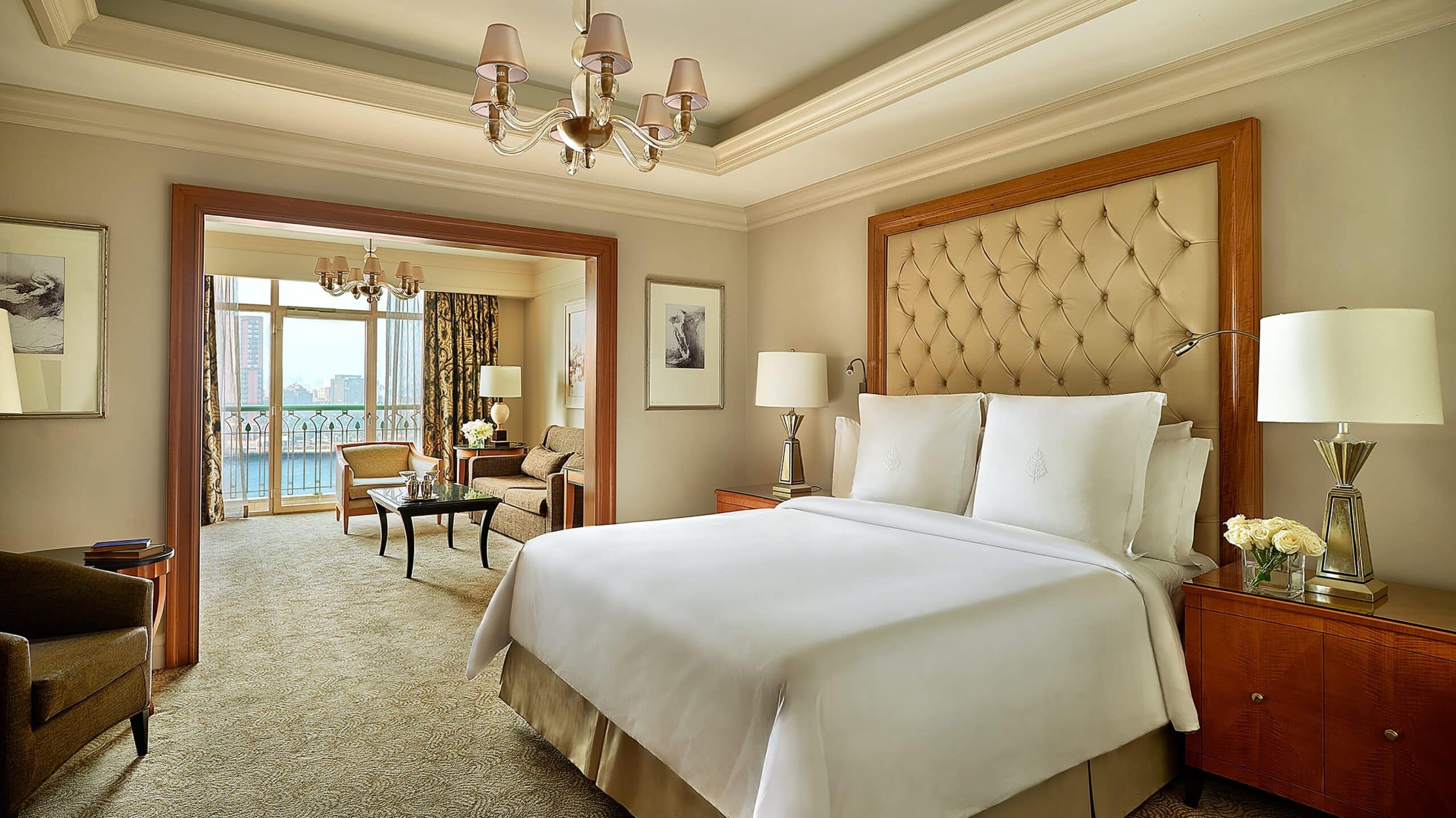 Room at the Four Seasons Hotel Cairo with king bed, sitting area, chandelier, and Nile view.