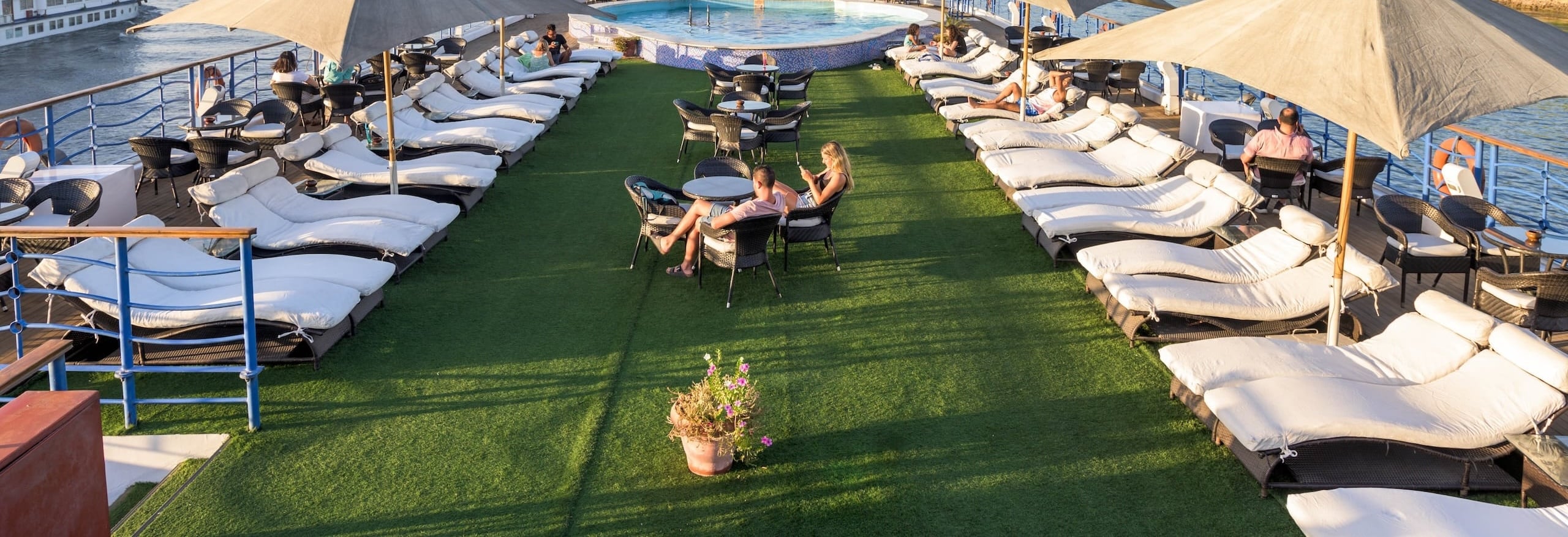 Lounge chairs and tables surround a small pool on the MS Royal Princess Nile Cruise deck.