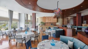 Elegant restaurant interior at The Nile Ritz-Carlton with round tables and colorful ceiling light.