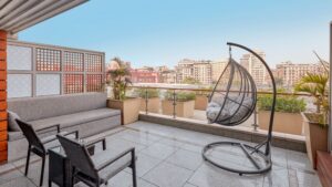 Rooftop terrace at The Nile Ritz-Carlton with seating, hanging chair, and cityscape view.
