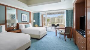 Enjoy a Nile Ritz-Carlton room: two beds, balcony view, TV, and seating area.