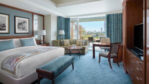 Spacious room at The Nile Ritz-Carlton with a large bed, sofa, table, and city view.