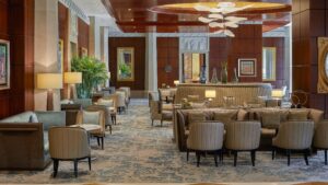 Elegant Nile Ritz-Carlton lobby with seating, artwork, and a large decorative chandelier.