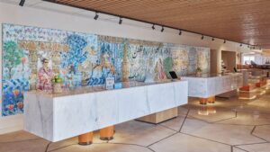 Modern Hyatt Centric Cairo West reception with marble desks and a colorful mural behind.