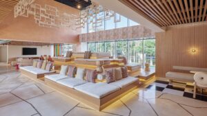 Modern lounge at Hyatt Centric Cairo West with tiered seating, cushions, and garden views.