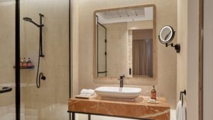 Modern bathroom at Hyatt Centric Cairo West with walk-in shower, large mirror, and marble countertop.