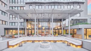 Modern patio at Hyatt Centric Cairo West with white seating, fire pit, and glass windows.