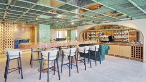 Modern cafe interior at Hyatt Centric Cairo West with green tiled ceiling and communal table.