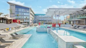 Modern outdoor pool at Hyatt Centric Cairo West with lounge chairs and umbrellas.