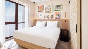 Small modern bedroom at Hyatt Centric Cairo West with a double bed, wall art, and neutral decor.