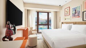 Modern Hyatt Centric Cairo West room with a large bed, art, and a window overlooking the pool.