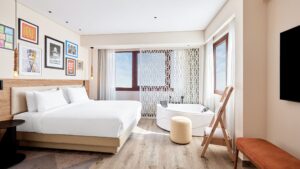 Modern Hyatt Centric Cairo West room with double bed, wall art, round tub, and large windows.