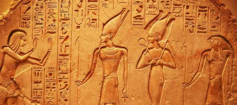 Ancient Egyptian hieroglyphs and figures carved on a stone relief, perfect for Egypt Holidays.